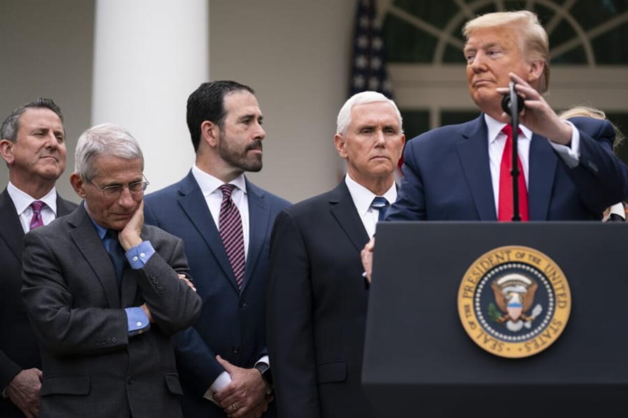 Dr. Anthony Fauci, director of the National Institute of Allergy and Infectious Diseases, listens as President Donald Trump speaks during a news conference on the coronavirus in the Rose Garden at the White House, Friday, March 13, 2020, in Washington.