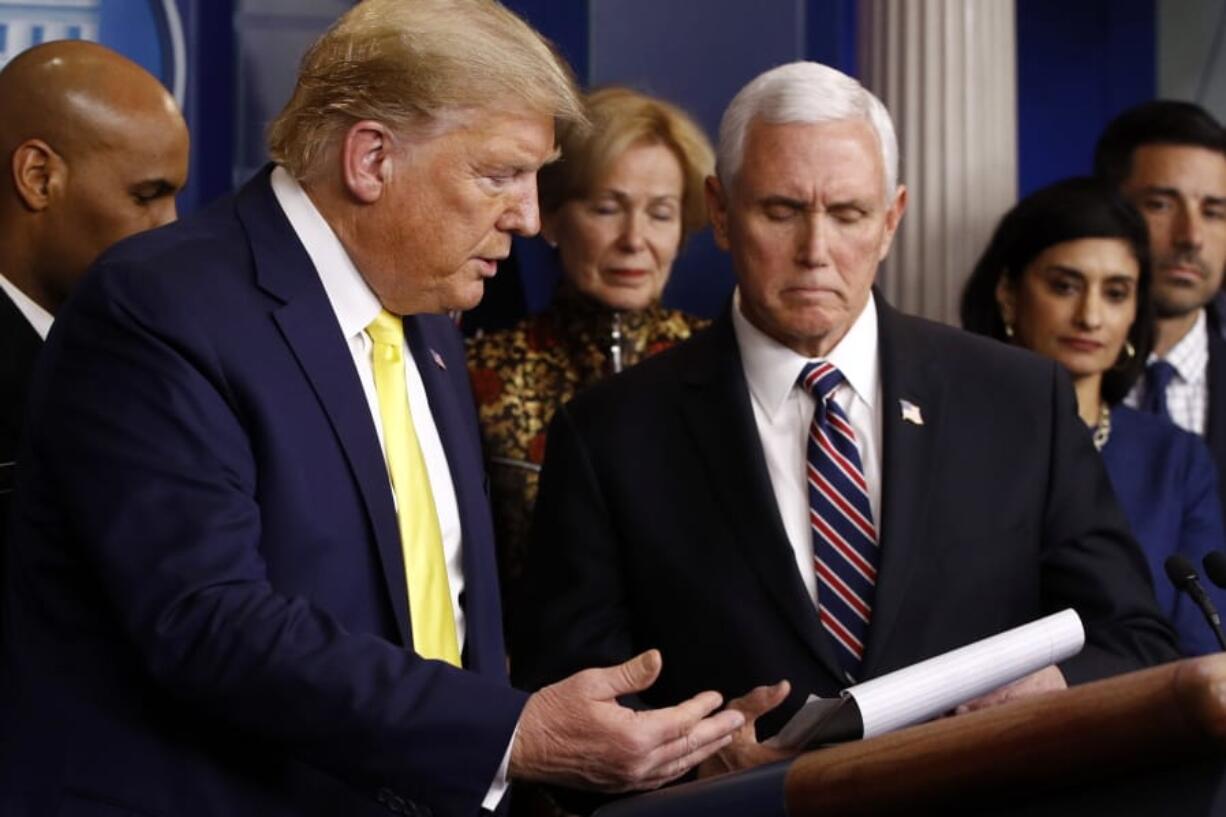 President Donald Trump gestures for Vice President Mike Pence to speaks in the briefing room of the White House in Washington, Monday, March 9, 2020, about the coronavirus outbreak.