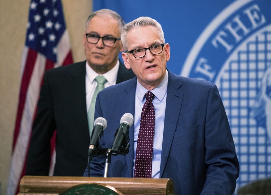 Dr. John Wiesman, secretary of the Washington State Department of Health, right, speaks about the measures done so far to prevent spreading and safety on Monday, March 2, 2020 in Olympia, Wash. Gov. Jay Inslee is in the background.