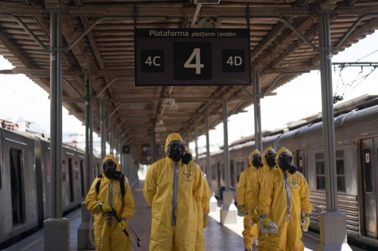 Soldiers stand in formation before disinfecting train cars Thursday at the central train station in Rio de Janeiro, Brazil.