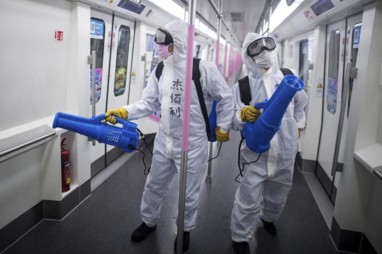 In this March 23, 2020 photo released by Xinhua News Agency, workers disinfect a subway train in preparation for the restoration of public transport in Wuhan, in central China&#039;s Hubei province. China&#039;s health ministry says Wuhan has now gone several consecutive days without a new infection, showing the effectiveness of draconian travel restrictions that are slowly being relaxed around the country.