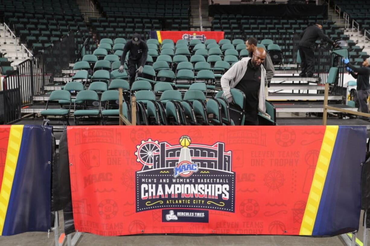 Workers dismantle seating after the men&#039;s and women&#039;s NCAA college basketball games at the Metro Atlantic Athletic Conference tournament were canceled, Thursday March 12, 2020, due to coronavirus concerns.