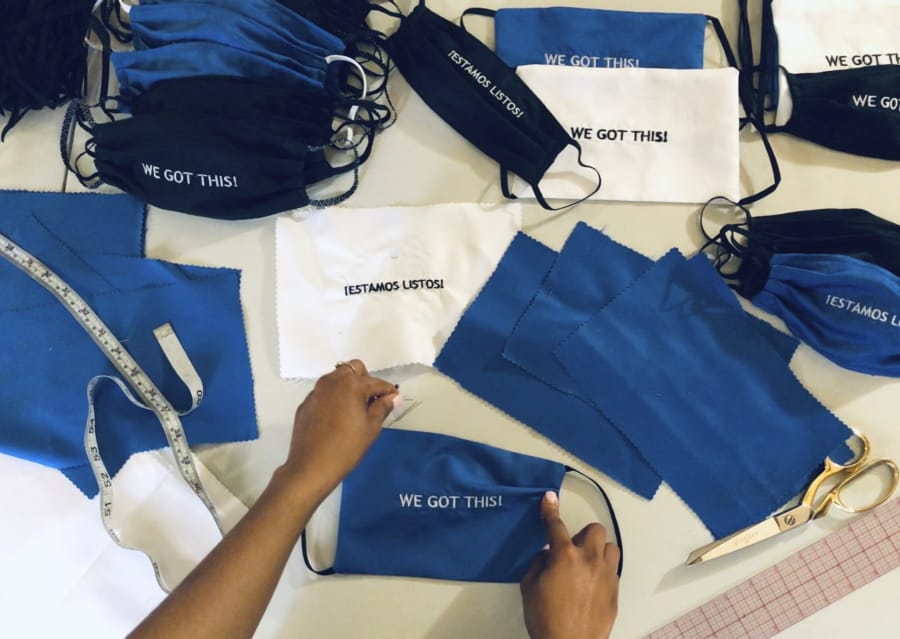 In this Sunday, March 22, 2020, photo, provided by Christina Hunter, Briana Danyele sews cloth face masks that say &quot;We Got This!&quot; in her mother&#039;s living room in Greer, S.C., which will be sent to health care workers. Legions of everyday Americans are sewing masks for desperate hospitals, nursing homes and homeless shelters amid the expanding coronavirus pandemic.