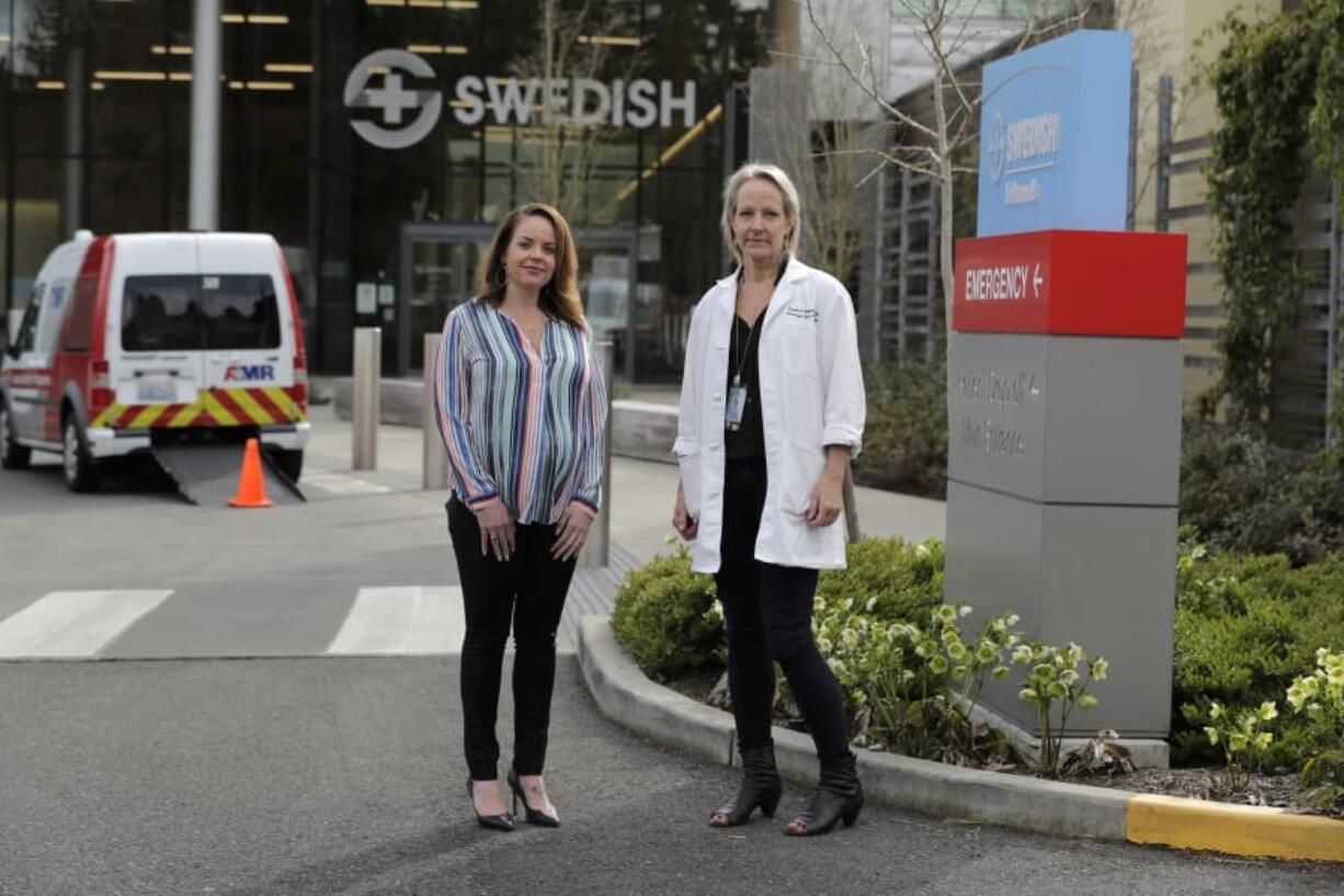 In this Tuesday, March 24, 2020, photo, Melissa Short, left, system executive director for women&#039;s health at Swedish Medical Center, and Dr. Tanya Sorensen, a practicing maternal fetal medicine physician at Swedish, and executive director for women&#039;s services, pose in front of the center in Edmonds, Wash., north of Seattle. Several dozen expectant moms who had planned to give birth at the birth unit of the center will now have to go elsewhere because the facility is being repurposed to treat victims of the new coronavirus. (AP Photo/Ted S.