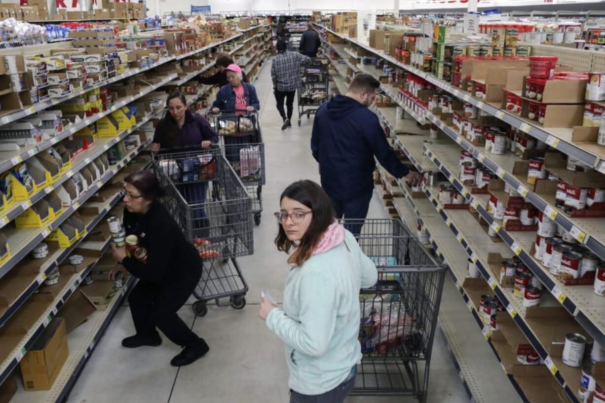 Shoppers stock up on canned items at WinCo Foods Friday, March 13, 2020 in Idaho Falls, Idaho. Idaho Gov. Brad Little declared a state of emergency Friday because of the new coronavirus.