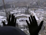 A Muslim prays from a hotel overlooking the Kaaba, the cubic building at the Grand Mosque, in the Muslim holy city of Mecca, Saudi Arabia, Wednesday, March 4, 2020. On Wednesday, Saudi Arabia&#039;s Deputy Health Minister Abdel-Fattah Mashat was quoted on the state-linked news site Al-Yaum saying that groups of visitors to Mecca from inside the country would now also be barred from performing the pilgrimage, known as the umrah.