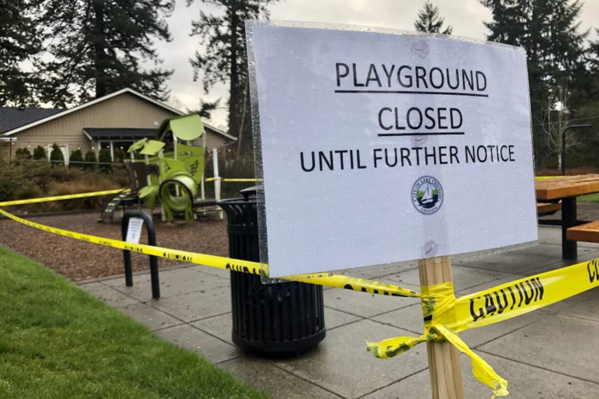 Police caution tape surrounds a playground in Lake Oswego, Ore., on Tuesday, March 24, 2020, the day after Gov. Kate Brown issued a statewide stay-at-home order that closed many businesses, as well as all playgrounds, basketball courts and sport courts.