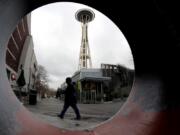 The Space Needle is seen through the round opening of a sculpture at the Seattle Center in Seattle.