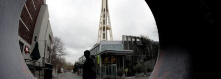 The Space Needle is seen through the round opening of a sculpture at the Seattle Center in Seattle.