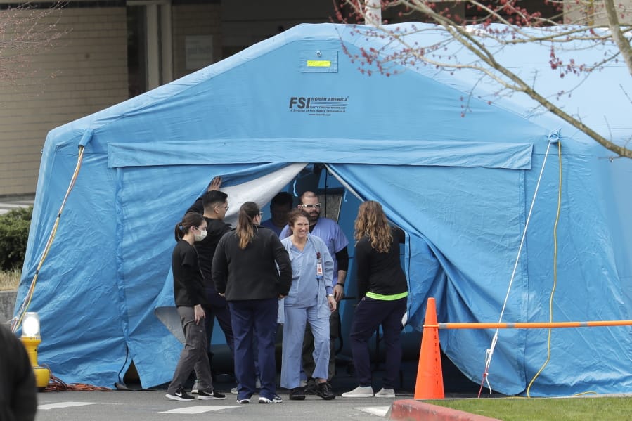 Workers exit a large tent set up in front of the emergency room at EvergreenHealth Medical Center, Tuesday, March 17, 2020, in Kirkland, Wash., near Seattle. In the area that has led the country in COVID-19 coronavirus cases and also across the country, hospitals are gearing up for an onslaught of coronavirus patients, but staff on the front lines are stretched thin and don&#039;t have the equipment they need to protect themselves from the highly contagious virus. (AP Photo/Ted S.