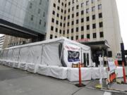 A new tent stands outside the emergency entrance of Harborview Medical Center Saturday, March 28, 2020, in Seattle. Harborview and University of Washington Medicine are preparing a &quot;surge plan&quot; that will enable its hospitals to better respond to the coronavirus outbreak. Under the plan, ambulatory patients with respiratory illness symptoms will be separated from other patients when they arrive at hospitals&#039; emergency departments and be directed to a new treatment area in a tent outside of the emergency department.