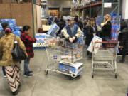 Shoppers wait their turn to pick up toilet paper that had just arrived at a Costco store in Tacoma on March 7. Within minutes, several pallets of toilet paper and paper towels were sold out as people continue to stock up on necessities due to fear of the COVID-19 coronavirus. Similar scenes have occurred at other Costco locations, including in Vancouver. (Ted S.