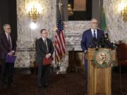 Gov. Jay Inslee, right, talks to the media about the decision to close schools in three counties in response to COVID-19, on March 12 in Olympia. At left are state Health Secretary John Wiesman, and Superintendent of Public Instruction Chris Reykdal.