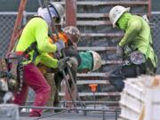 Construction workers labor at the construction site off South Dixie Highway and SW 37th Avenue in Coral Gables, Fla., on March 31, 2020.