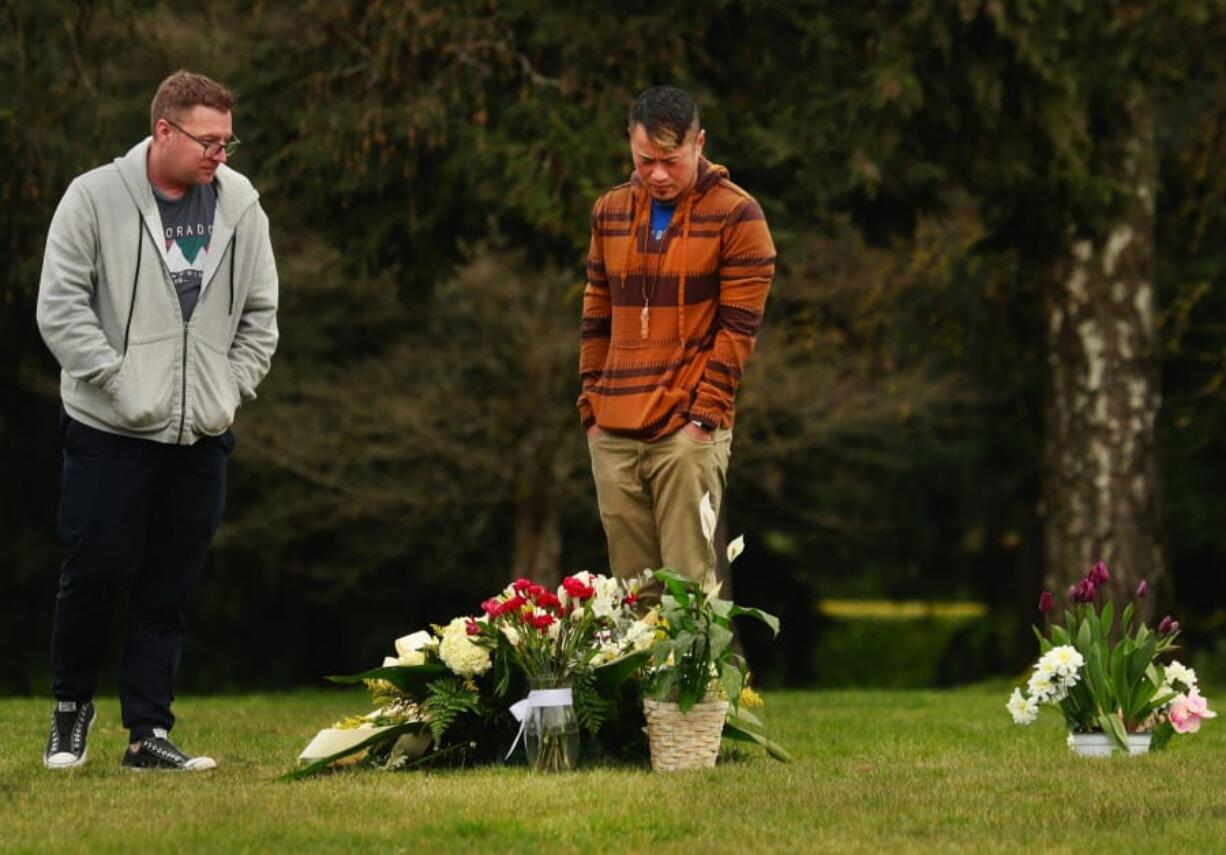 Vince Viet Nguyen, center, visits his father Hoang Nguyen&#039;s grave Friday with his husband Michael Burleson, left. Hoang Nguyen died from COVID-19 and was buried on Wednesday, about 30 feet from his son Peter Nguyen.