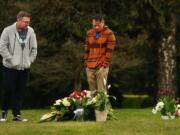 Vince Viet Nguyen, center, visits his father Hoang Nguyen&#039;s grave Friday with his husband Michael Burleson, left. Hoang Nguyen died from COVID-19 and was buried on Wednesday, about 30 feet from his son Peter Nguyen.