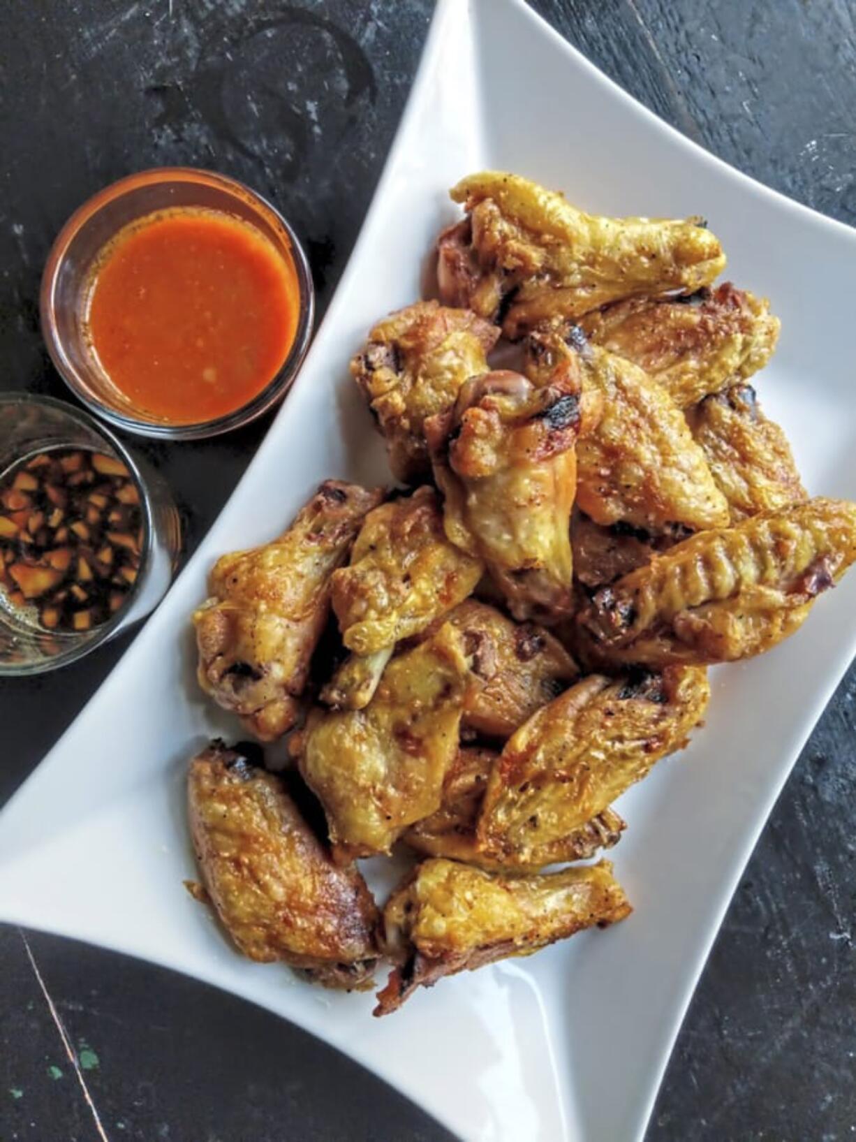 Crispy wings are more fun when served with two sauces, including Buffalo and ginger-soy.