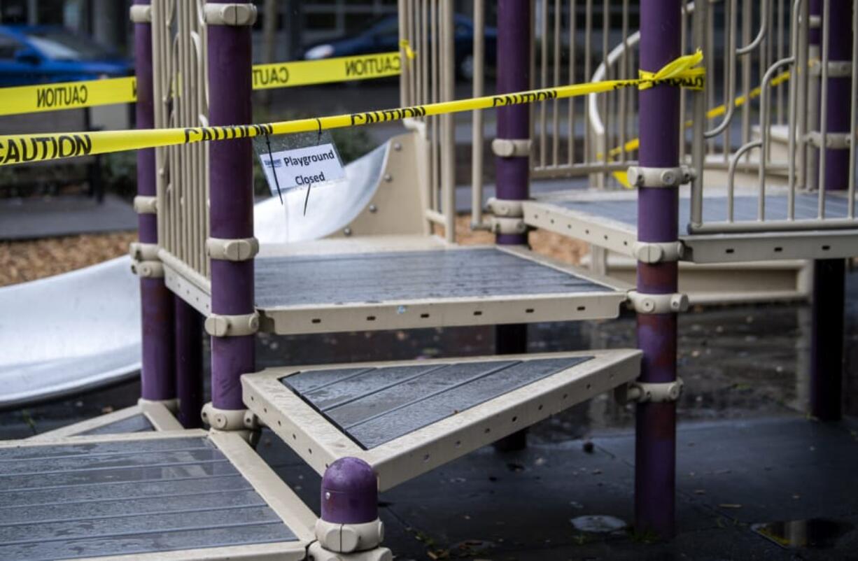 Caution tape closes off play structures at Esther Short Park in Vancouver on March 24. Most city-operated parks remain open, but play structures and sports courts still are off-limits.