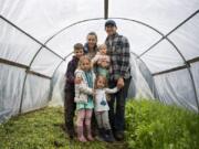 Patricia and Dillon Haggerty are pictured with their children Quintin, 8, from left, Cadence, 6, Nora, 3, and Juniper, 1, at their family farm Dilish in Clark County on Tuesday. The Haggertys both lost their jobs in the service industry due to closures caused by the COVID-19 pandemic. The couple said their small farm business has also been affected.