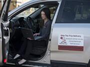 Katie O&#039;Daniel, owner and driver with Skip the Trip Delivery, pauses for a portrait with her laptop in Washougal before making a delivery in Camas.