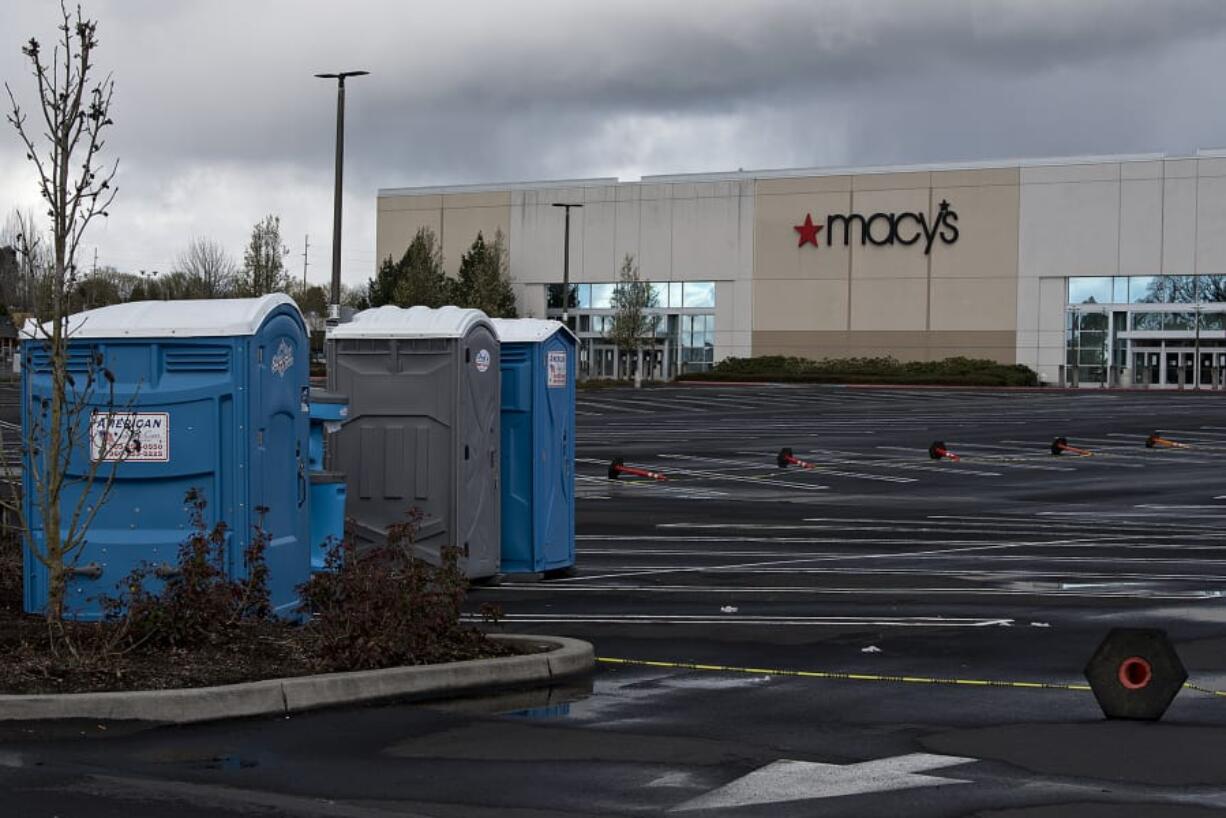 Portable toilets and hand-washing stations are available for the homeless in the empty parking lot at Vancouver Mall on Tuesday. A safe-parking zone will open Thursday for people living in their cars.