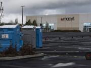 Portable toilets and hand-washing stations are available for the homeless in the empty parking lot at Vancouver Mall on Tuesday. A safe-parking zone will open Thursday for people living in their cars.