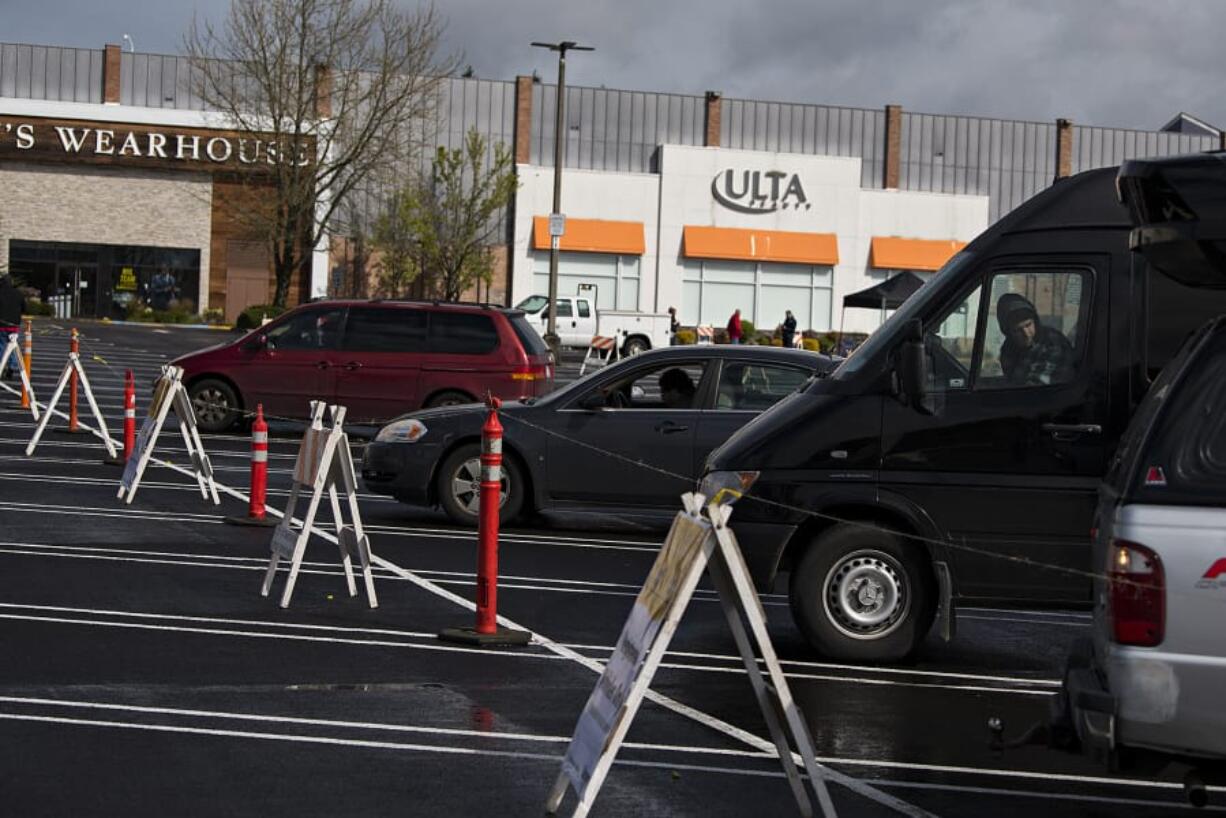 Car campers park their vehicles with space between them as they take refuge during the COVID-19 crisis at Vancouver Mall on Thursday. It was the first day officials were registering vehicles on a first-come, first-served basis to park at the mall. Participants have access to portable toilets and hand-washing stations.