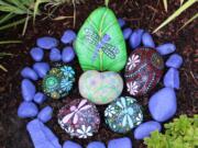 Painted rocks, like this dragonfly-themed display by Diane Stevens, are cropping up in yards around Clark County.