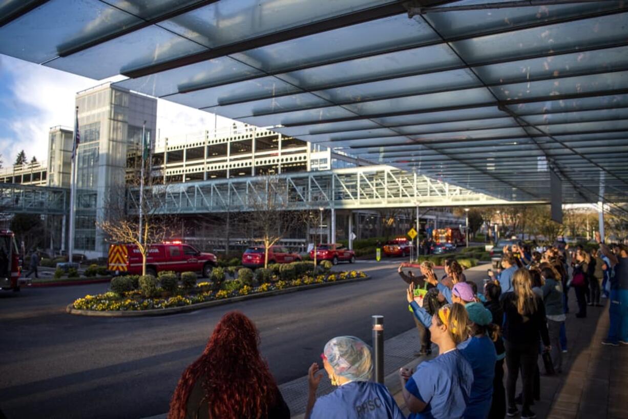 Firefighters and paramedics with Clark County Fire District 6 drive through Legacy Salmon Creek Medical Center in Vancouver on Wednesday to applaud medical professionals for their dedication during the novel coronavirus outbreak.