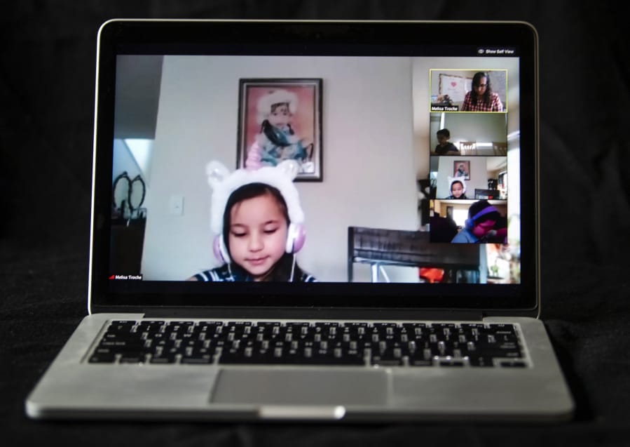 Pioneer Elementary School first-grader Andria Gruetske listens to his teacher, Melisa Troche, as the class joins in on a teleconference call in Vancouver on Monday.