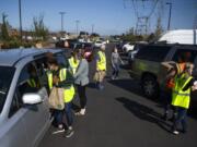 Cars fill the parking lots and line the streets surrounding the Clark County Food Bank to pick up food Tuesday afternoon. The food bank packed boxes and bags filled with food to give away to people in need during the COVID-19 pandemic.