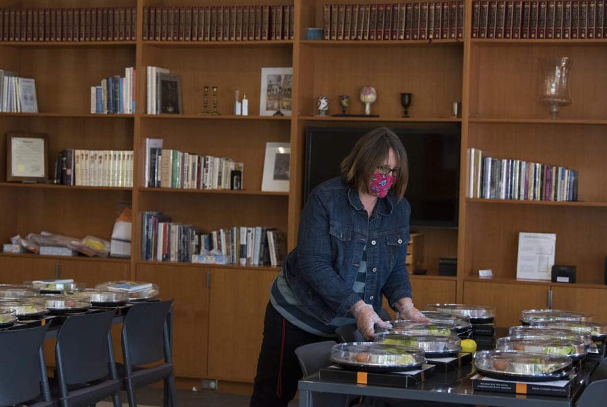 Above, Renita Keatley of Chabad Jewish Center of Clark County sets out Seder plate kits for local families to celebrate Passover at home on Wednesday.