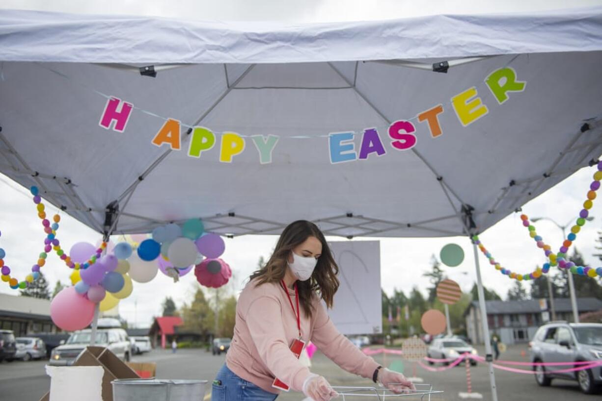 Jessica Mofford cleans a metal basket used to deliver bags of plastic Easter eggs during Activate Church&#039;s drive-thru Easter egg hunt in Camas on Saturday morning, April 11, 2020.