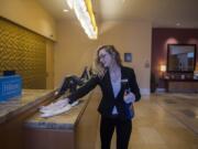 Guest service agent Libby Lusk keeps the front desk at the Hilton Vancouver Washington disinfected while working in an empty lobby on Wednesday morning. The hospitality industry has been hit hard by the COVID-19 crisis.