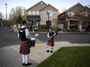 Drummer Daniel Gillespie, 15, and bagpiper Logan Gillespie, 12, perform a brief concert Wednesday for their Battle Ground neighbors. At far right across the street is Bev Lohrman, a night-shift nurse who cares for COVID-19 patients in the intensive care unit at PeaceHealth Southwest Medical Center. Every time the brothers play her late mother&#039;s favorite song, &quot;Amazing Grace,&quot; Lohrman said she hears her mother reassuring her that everything will be OK.