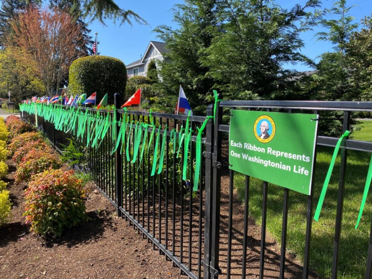 NORTHWEST VANCOUVER: Jim Mains and his 4-year-old son, Remington, tie a green ribbon to the fence in the front of their home each day, representing a new victim.