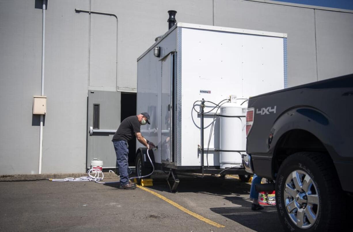 Volunteer Bob Bowling sets up the shower trailer at Living Hope Church in Vancouver on Friday. Due to the spread of coronavirus, the showers are now available on additional days for people in need.