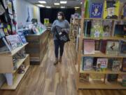 Ruthie Prasil, owner of Dickens Children&#039;s Books, prepares to drop off an order to a customer outside her store in Uptown Village on Thursday.