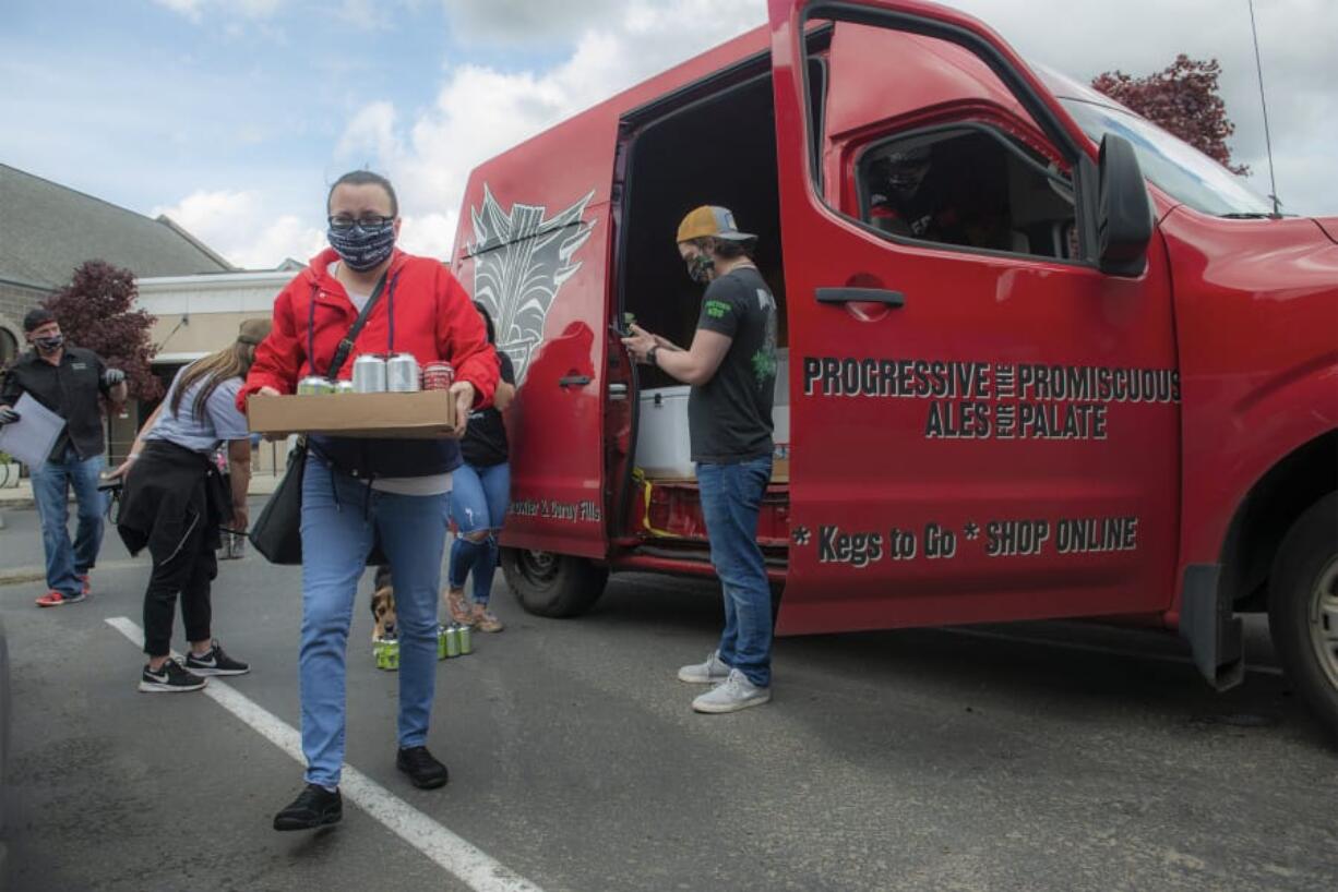 Marie Yager of Battle Ground leaves the Heathen Brewing beer truck with her order on Saturday.