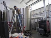 Darin Kyle of Quartz Mountain Distillery keeps an eye on the mash run in preparation for making hand sanitizer to help during the COVID-19 pandemic at his Walnut Grove business.