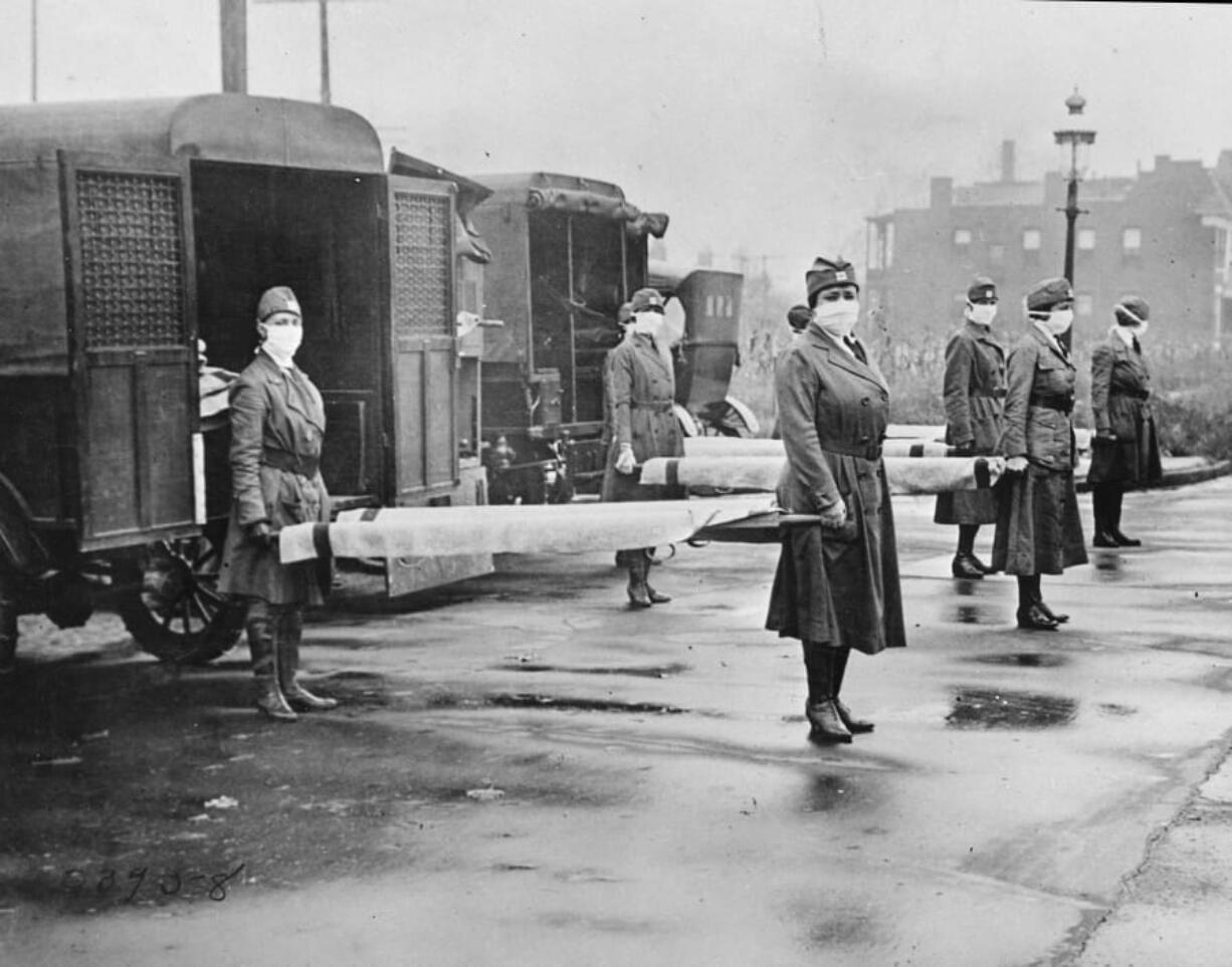 In this October 1918 photo made available by the Library of Congress, St. Louis Red Cross Motor Corps personnel wear masks as they hold stretchers next to ambulances in preparation for victims of the influenza epidemic. A century after one of historyCfUs most catastrophic disease outbreaks, scientists are rethinking how to guard against another super-flu like the 1918 influenza that slaughtered tens of millions as it swept the globe in mere months.