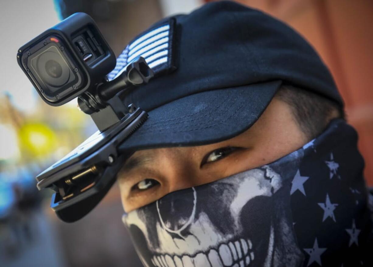 Eddie Song a Korean American entrepreneur, arrives at his motorcycle storage garage wearing a video camera clipped to his cap and a face mask due to COVID-19, Sunday April 19, 2020, in East Village neighborhood of New York. &quot;I was assaulted a few months ago by someone who said that corona[virus] was created by Asians,&quot; said Song. Since the assault, Song routinely wears cameras and extra padding under his jacket while walking or riding, prepared to record and intervene to stop racist attacks against Asians being blamed for COVID-19.