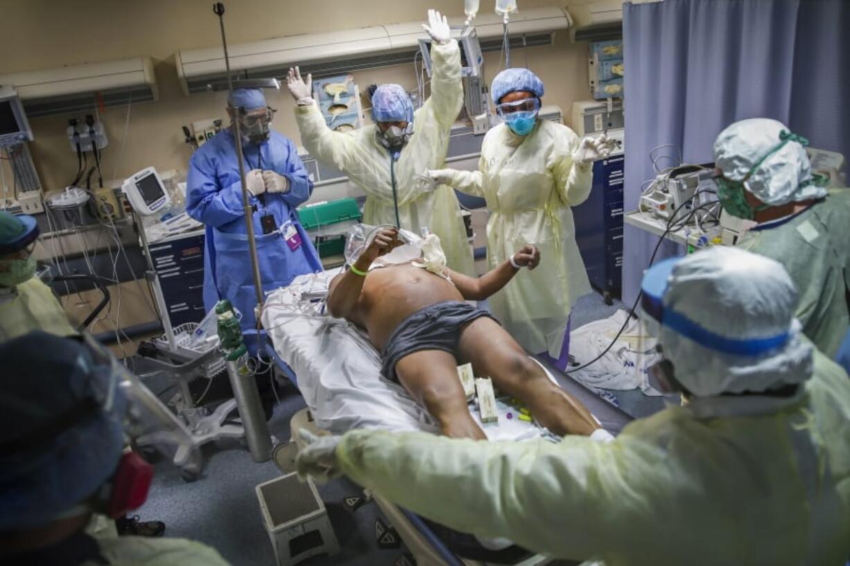 Nurses and doctors clear the area before defibrillating a patient with COVID-19 who went into cardiac arrest, Monday, April 20, 2020, at St. Joseph&#039;s Hospital in Yonkers, N.Y. The emergency room team successfully revived the patient.