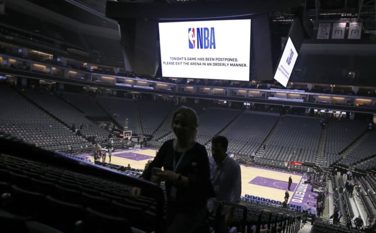 Fans leave the Golden 1 Center after the NBA basketball game between the New Orleans Pelicans and Sacramento Kings was postponed at the last minute in Sacramento, Calif., Wednesday, March 11, 2020. The league said the decision was made out of an &quot;abundance of caution,&quot; because official Courtney Kirkland, who was scheduled to work the game, had worked the Utah Jazz game earlier in the week. A player for the Jazz tested positive for the coronavirus.