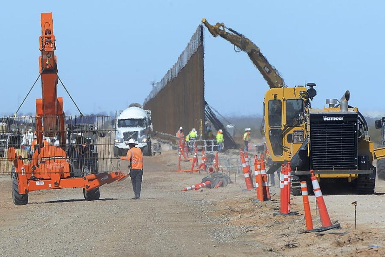 Workers install a new section of 30-foot-high &quot;bollard wall&quot; March 23 at a construction site south of Yuma, Ariz., near the border between the United States and Mexico.