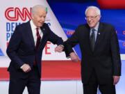 Former Vice President Joe Biden, left, and Sen. Bernie Sanders, I-Vt., right, greet each other before they participate in a Democratic presidential primary debate at CNN Studios in Washington, Sunday, March 15, 2020.