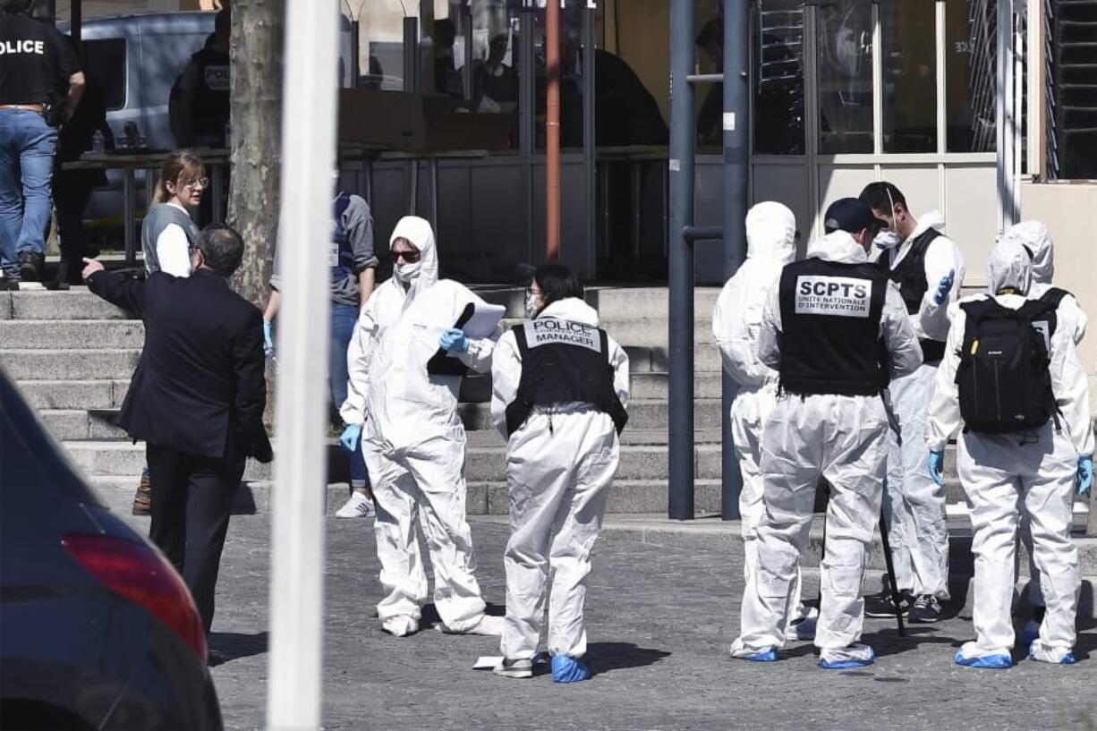 Police officers investigate after a man wielding a knife attacked residents venturing out to shop in the town under lockdown, Saturday April 4, 2020 in Romans-sur-Isere, southern France. The alleged attacker was arrested by police nearby, shortly after the attack. Prosecutors did not identify him. They said he had no documents but claimed to be Sudanese and to have been born in 1987.