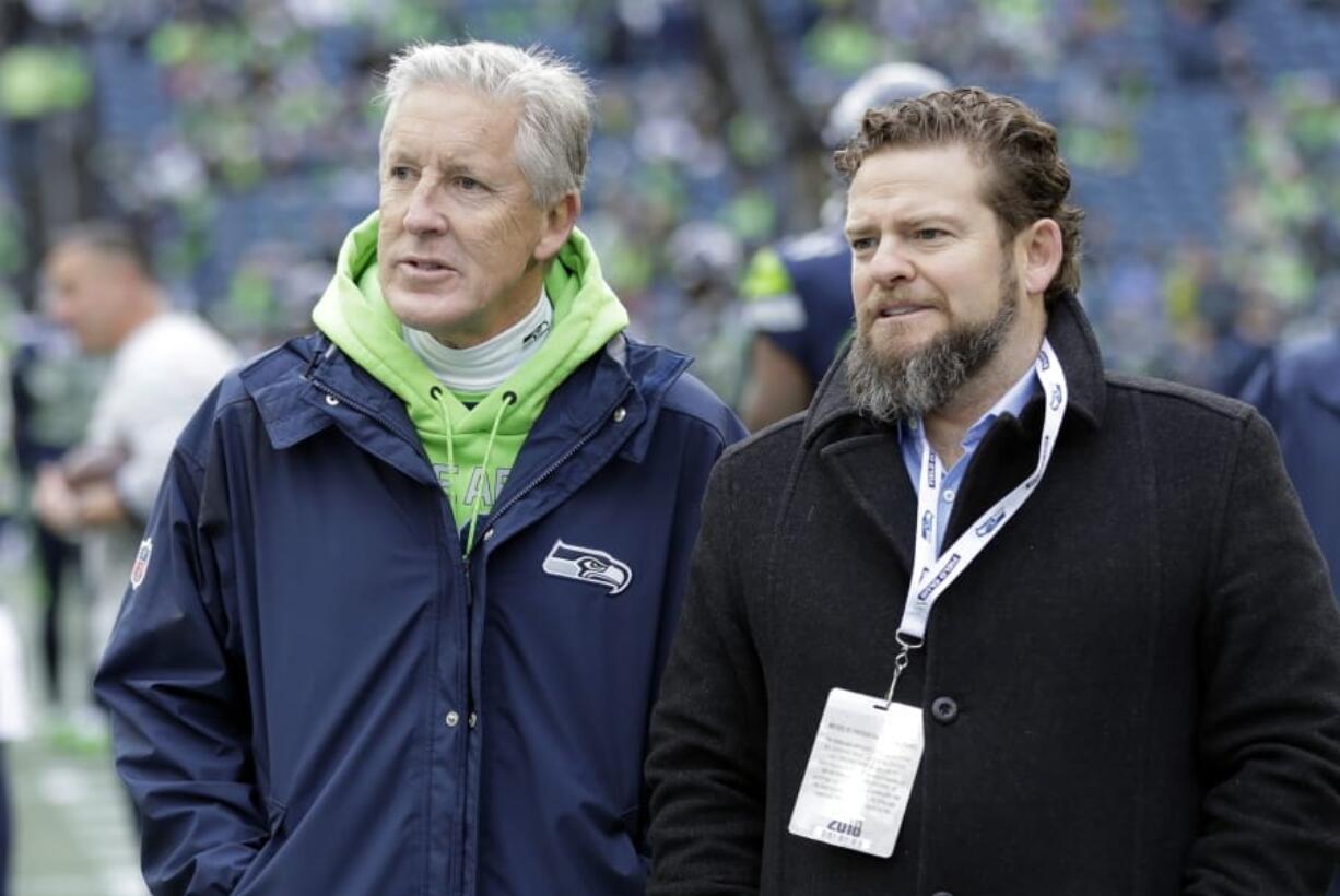 FILE - In this Dec. 30, 2018, file photo, Seattle Seahawks coach Pete Carroll, left, talks with general manager John Schneider before  the team&#039;s NFL football game against the Arizona Cardinals in Seattle. There is a clear and obvious need for the Seahawks to address along the defensive line and it happens to be one of the deeper positions of talent in the entire draft. That may be far too simplistic and straightforward for Schneider and Carroll. Schneider is always good for a few surprises in the draft, and more than a couple of trades.