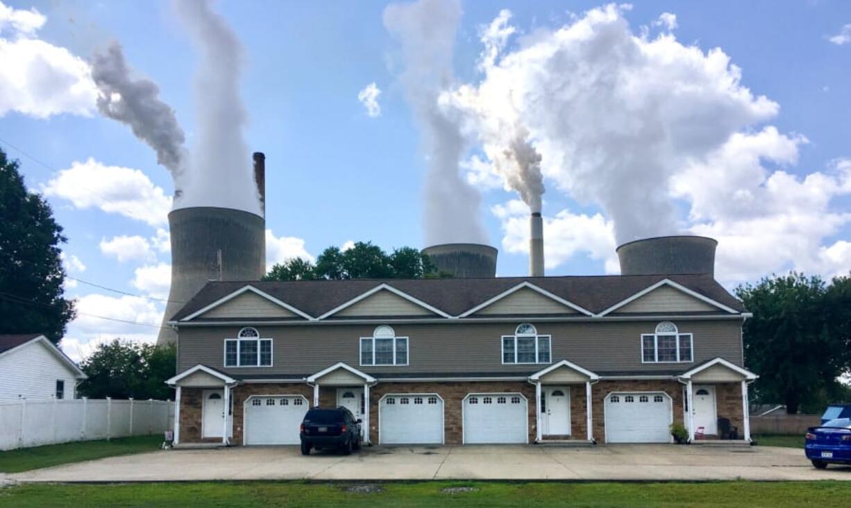 FILE - In this Aug. 23, 2018, file photo, a coal-fired plant in Winfield, W.Va, is seen from an apartment complex in the town of Poca across the Kanawha River. The Trump administration is gutting an Obama-era rule that compelled coal plants to cut back emissions of mercury and other human health hazards, limiting future regulation of air pollutants by petroleum and coal plants.