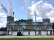 FILE - In this Aug. 23, 2018, file photo, a coal-fired plant in Winfield, W.Va, is seen from an apartment complex in the town of Poca across the Kanawha River. The Trump administration is gutting an Obama-era rule that compelled coal plants to cut back emissions of mercury and other human health hazards, limiting future regulation of air pollutants by petroleum and coal plants.